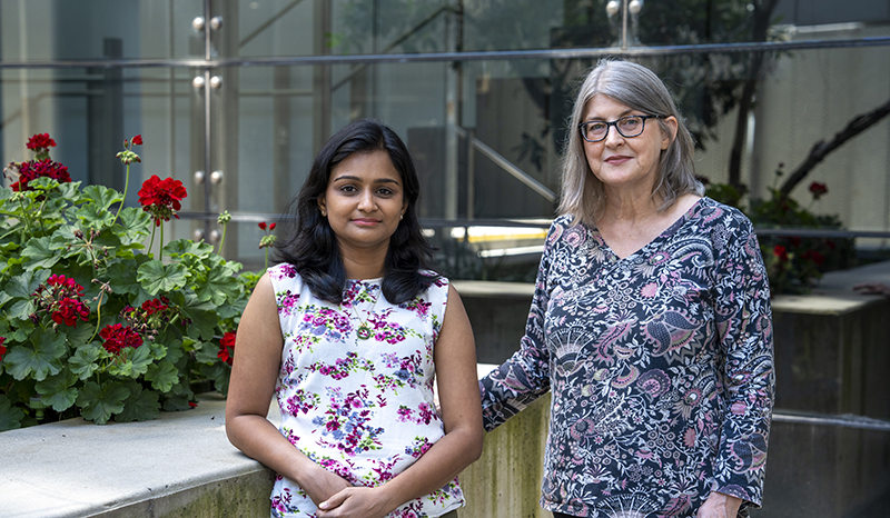 Dr Agalya Periasamy and Dr Jacqui Gulbis standing near a garden