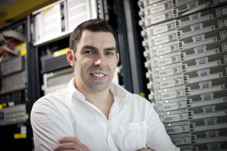 Associate Professor Tony Papenfuss standing in front of computers
