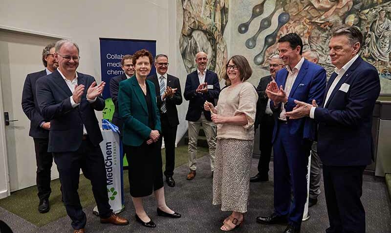 A group of smiling people are photographed applauding