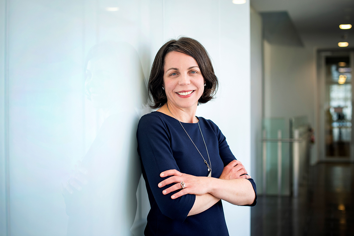 Professor Kate Sutherland photographed leaning against a white wall